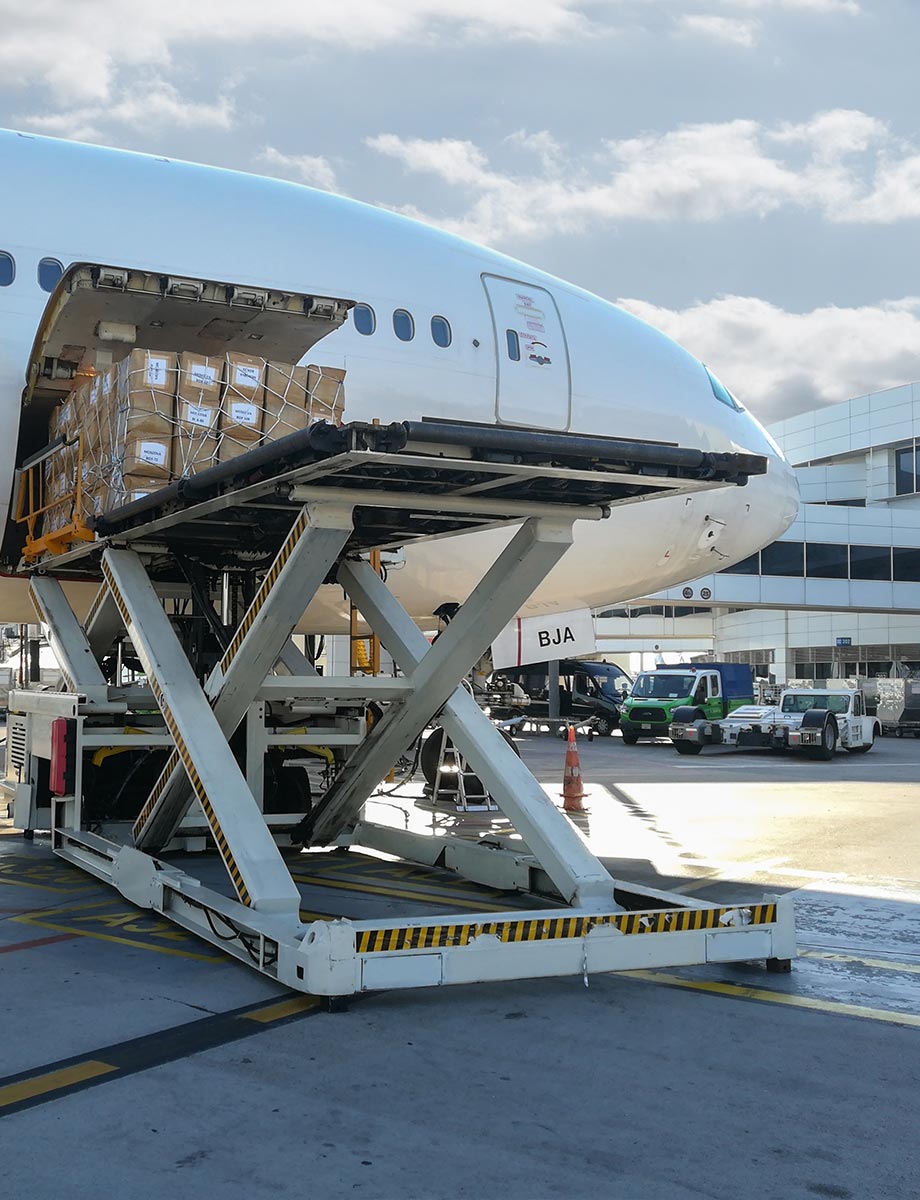 Air freight cargo on a raised loading platform beside an aircraft’s open cargo door