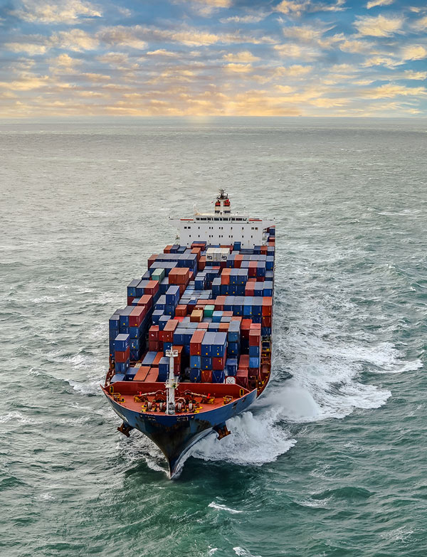 Container ship carrying stacked shipping containers at sea for ocean freight transport Container ship carrying stacked shipping containers at sea for ocean freight transport